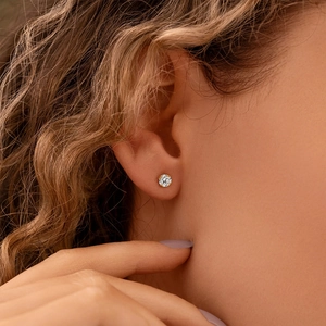 Gros plan d'une boucle d'oreille en argent S925 avec diamant scintillant sur l'oreille