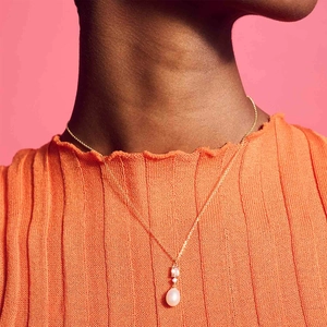 Dettaglio della collana in argento S925 con perla e pendente rosa indossata sul collo
