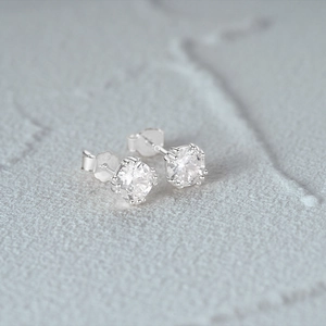 Gros plan sur les clous d'oreilles en argent 925 avec zirconiums ronds sertis en couronne