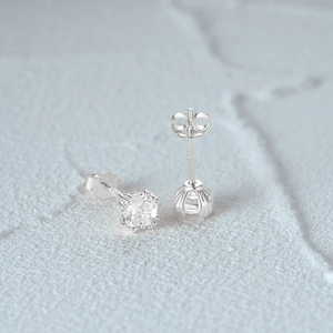 Gros plan sur la tige de boucle d'oreille en argent S925 montrant le poinçon et le fermoir papillon