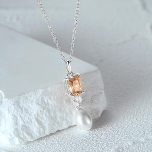 Dettaglio della collana in argento S925 con gemma champagne e ciondolo a perla a goccia