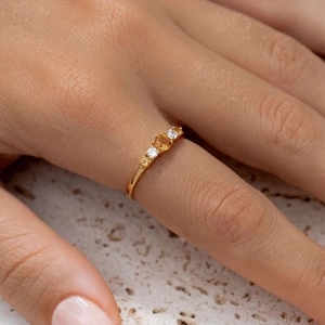 Close-up of vintage S925 silver ring with orange zircon stones and gold finish
