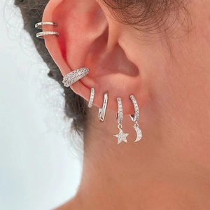 Macro shot of S925 sterling silver ear cuffs and earrings set with star and moon patterns