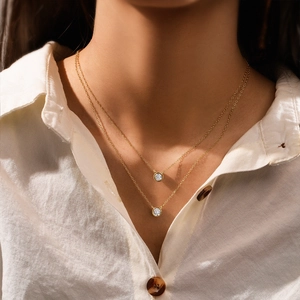 Detail of double-layered gold necklace with sparkling round cubic zirconia on a model
