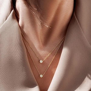 Close-up of double-layered gold S925 silver necklace with sparkling zircon pendants