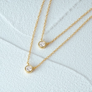 Macro detail of gold layered S925 sterling silver necklaces with bezel-set round zircon