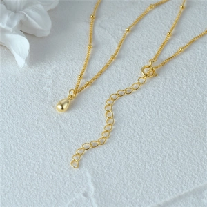 Makroaufnahme der goldenen Tropfenhalskette mit feiner Perlenkette und verstellbarem Verschluss
