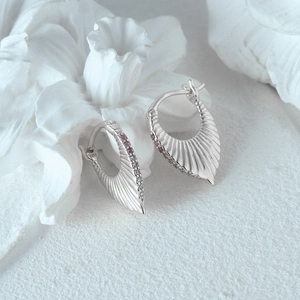 Macro detail of S925 sterling silver fan earrings with purple crystals and fine texture