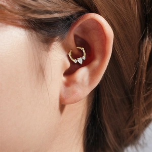 Detailed close-up of a gold S925 silver hoop earring with marquise-cut opal on ear cartilage