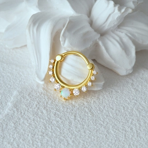 Detailed macro of gold S925 sterling silver hoop with marquise opal and sparkling zircons