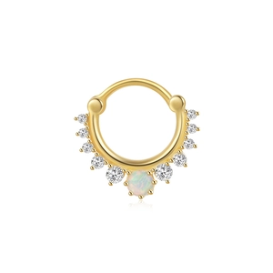 Detail of gold cartilage hoop ring with marquise opal stone and white zircon stones