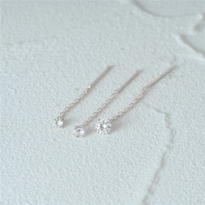 Dettaglio degli orecchini a catena con nappe in argento 925 e borchie con diamanti tondi
