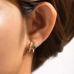 Detalle de pendientes C de plata S925 dorada con circón verde y piedras pavé