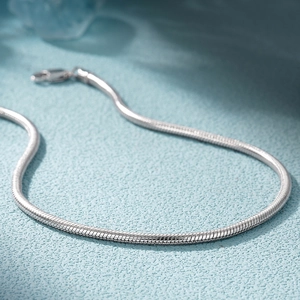 Close-up of a high-polished 925 sterling silver snake chain bracelet with lobster clasp