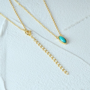Detail of gold necklace with marquise turquoise pendant and adjustable chain extender