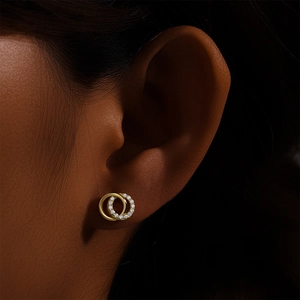 Gros plan de boucles d'oreilles doubles anneaux entrelacés avec zircons scintillants