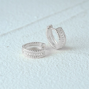 Close-up of S925 sterling silver hoop earrings with twisted edges and zircon inlay