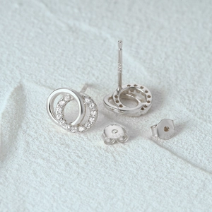 Vue macro de boucles d'oreilles double cercle en argent 925 serties de zircons cubiques