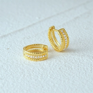 Macro shot of gold-plated S925 sterling silver hoop earrings with twisted texture and zircon