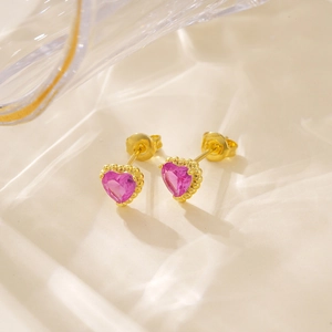 Detailopname van hartvormige roze edelsteen oorbellen met gouden kraalzetting