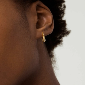 Close-up of gold teardrop hook earrings featuring pavé-set sparkling cubic zirconia stones