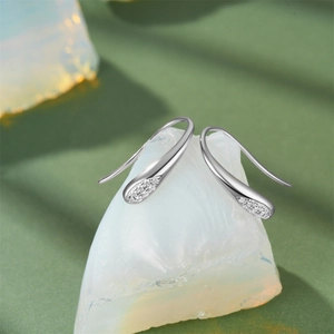 Macro detail of S925 sterling silver teardrop earrings with crystals on natural stone