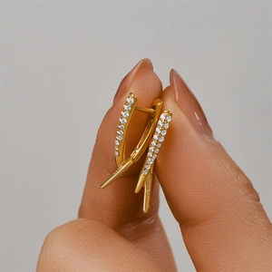Detailed macro view of S925 sterling silver stamp on gold V-shaped zircon earrings
