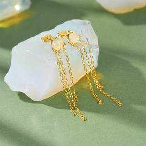 Detail of S925 silver fringe earrings with white opal stones and gold chain tassels