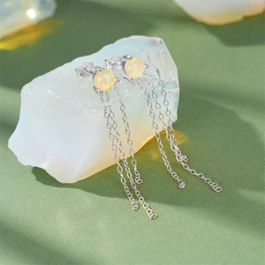 Macro detail of S925 silver fringe earrings with opal stone and hanging chain tassels