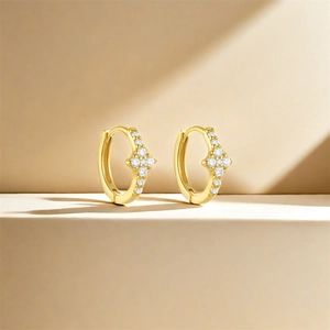 Macro detail of gold hoop earrings featuring delicate star-shaped zircon inlays