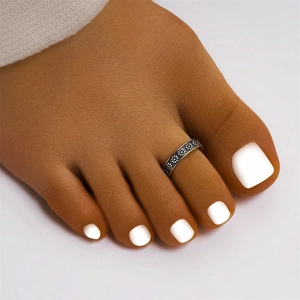 Detailed view of a vintage silver toe ring featuring an oxidized floral daisy pattern