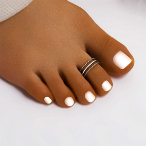 Detailed macro view of S925 sterling silver triple-layer heart toe ring on foot