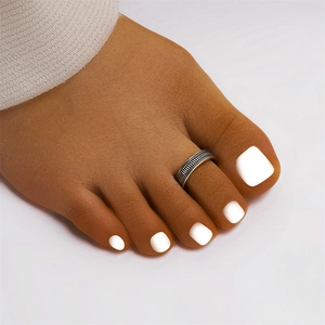 Macro shot of vintage S925 sterling silver lotus toe ring with woven texture on model