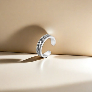 Close-up of vintage s925 silver lotus toe ring with textured braided patterns on the band