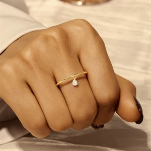 Detailed view of a gold s925 ring featuring a minimalist band and a pear-cut stone charm