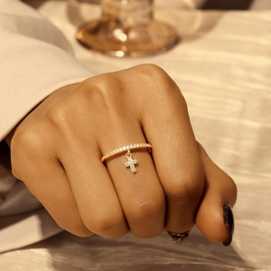 Close-up of a gold-plated S925 silver ring featuring a sparkling cross charm and pavé stones