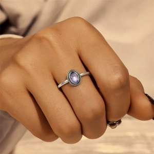S925 silver lotus ring with oval purple gemstone shown on a hand in a macro view