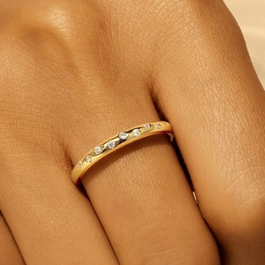 Macro shot of gold S925 silver ring with sparkling round-cut pave stones on finger