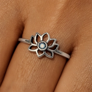 Detail of S925 sterling silver lotus ring with blue opal stone on a female finger