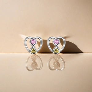 Macro shot of S925 silver heart earrings with infinity symbol and pink yellow gems