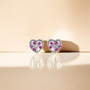 Macro detail of S925 silver heart stud earrings with pink cubic zirconia stones