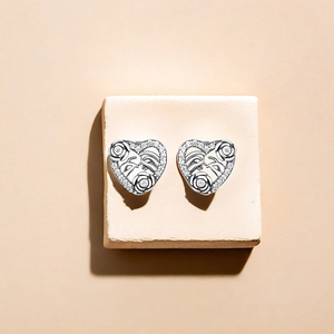 Macro detail of S925 silver heart earrings with rose relief and sparkling zircon inlay
