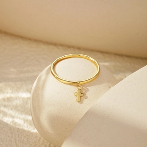 Close-up of S925 sterling silver gold plated ring with dangling cross charm detail