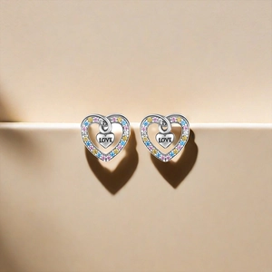 Detail of silver heart stud earrings with colorful zircons and heart shadow effect