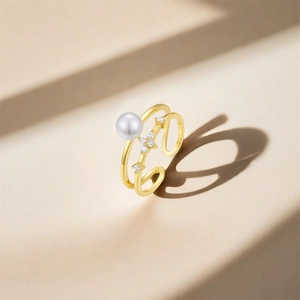 Detail of s925 silver adjustable ring with pearl and floral zircon accents in gold finish