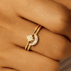 Macro detail of a double-layered gold ring set with crescent moon and star zircon accents
