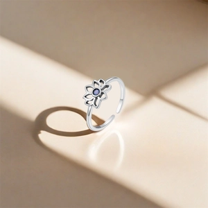 Detailed macro of S925 sterling silver lotus ring with a blue gemstone inlay and open band
