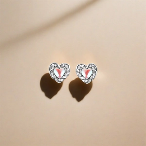 Detailed macro shot of S925 silver heart stud earrings with cubic zirconia and red detail