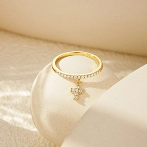 Detail of S925 sterling silver gold ring with pavé zircon band and a cross pendant