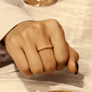 Detail of elegant gold double-layered ring with micro-pave diamonds on a silk background